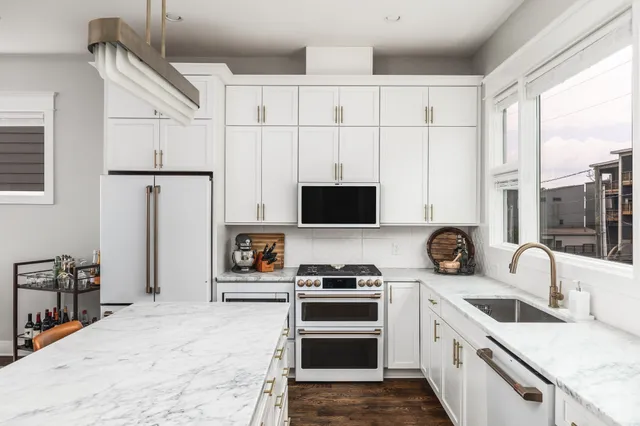 a kitchen with stainless steel appliances a stove a sink and a refrigerator