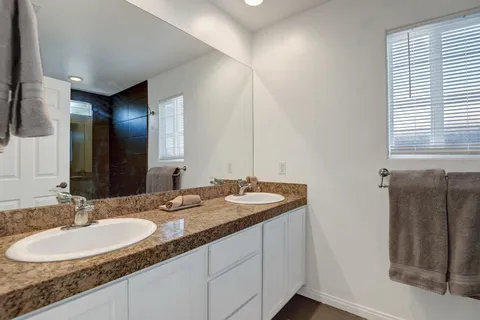 a bathroom with a granite countertop sink and a mirror