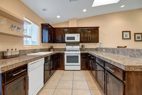 a kitchen with stainless steel appliances granite countertop a stove sink and cabinets