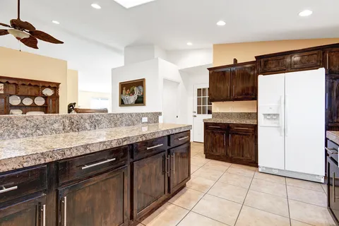 a kitchen with stainless steel appliances granite countertop a refrigerator and a stove top oven