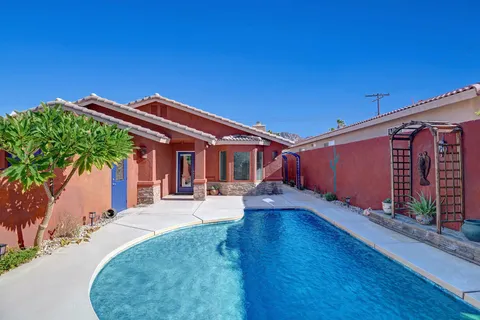 a view of a house with backyard and sitting area