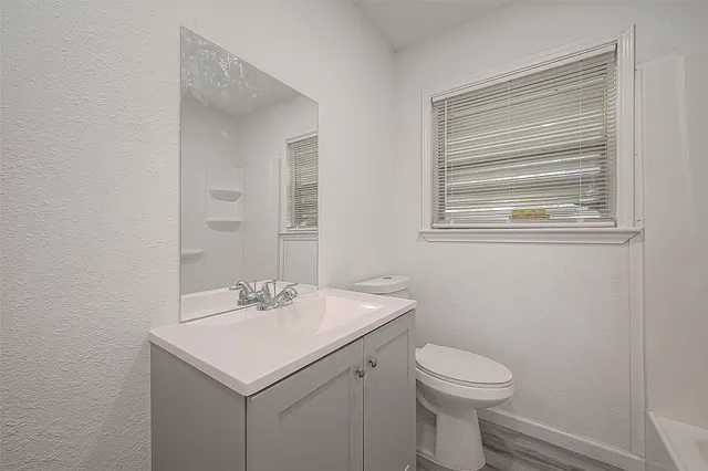 a bathroom with a sink toilet and a mirror