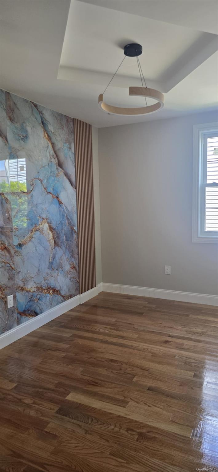 108-33 164th Street Queens, NY 11433 - Photo 18 of 20 a view of an empty room with wooden floor and a window