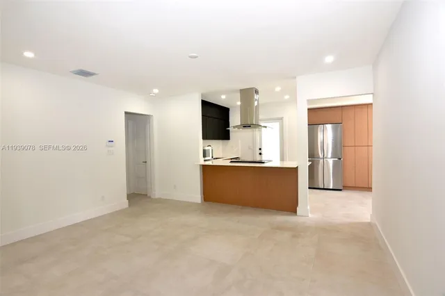 a large kitchen with a sink and an empty room