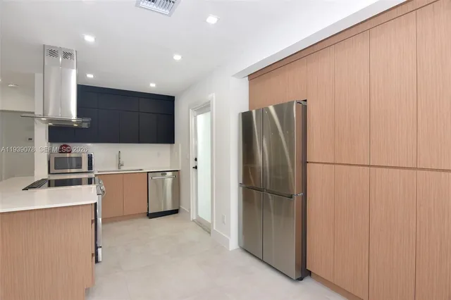 a kitchen with stainless steel appliances granite countertop a refrigerator and a stove top oven
