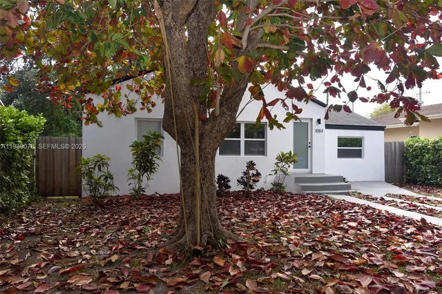 a front view of a house with a tree