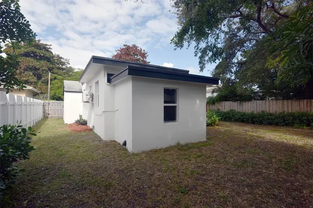 a front view of house with a garden