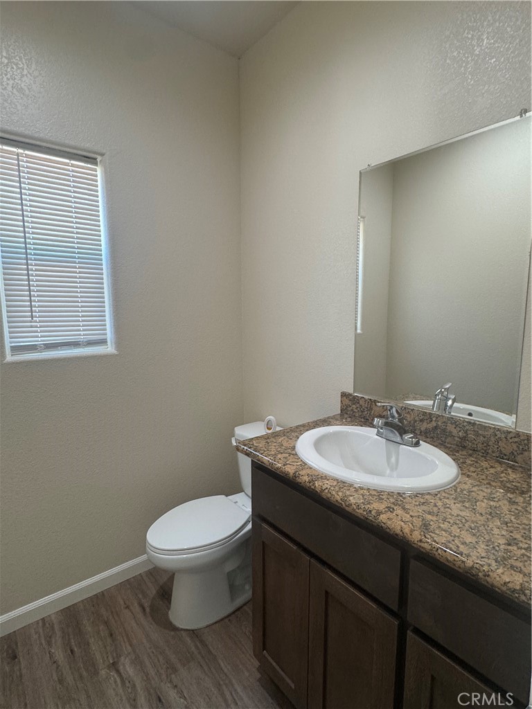 1339 Playa Del Rey Drive Merced, CA 95348 - Photo 15 of 48 a bathroom with a granite countertop toilet a sink and a mirror