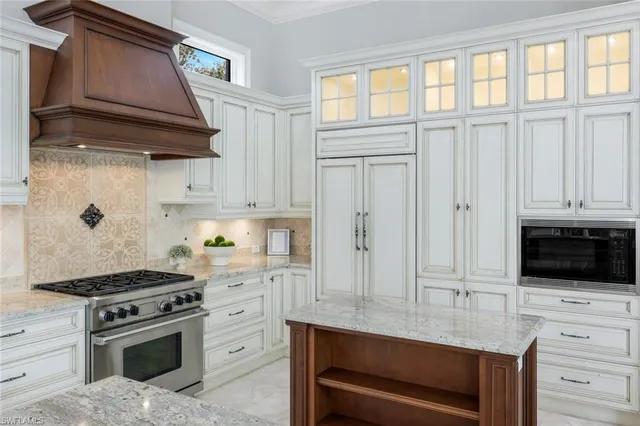 a kitchen with white cabinets and appliances