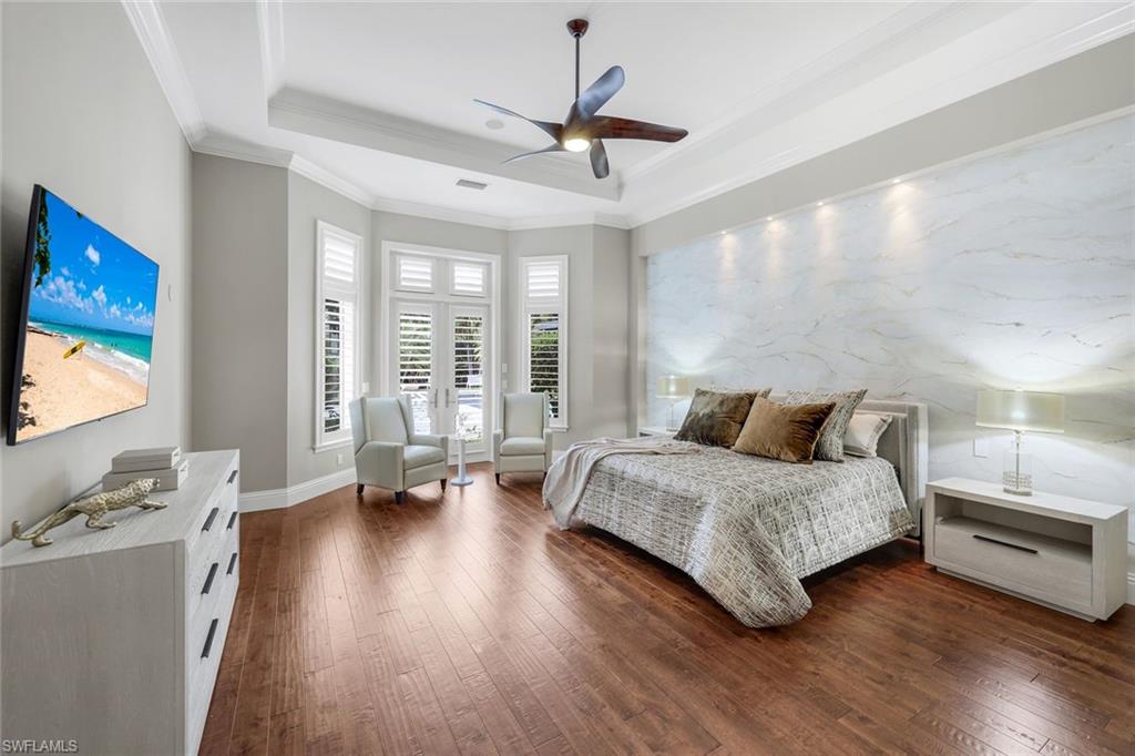 14459 Marsala Way Naples, FL 34109 - Photo 20 of 50 a spacious bedroom with a bed and a chandelier
