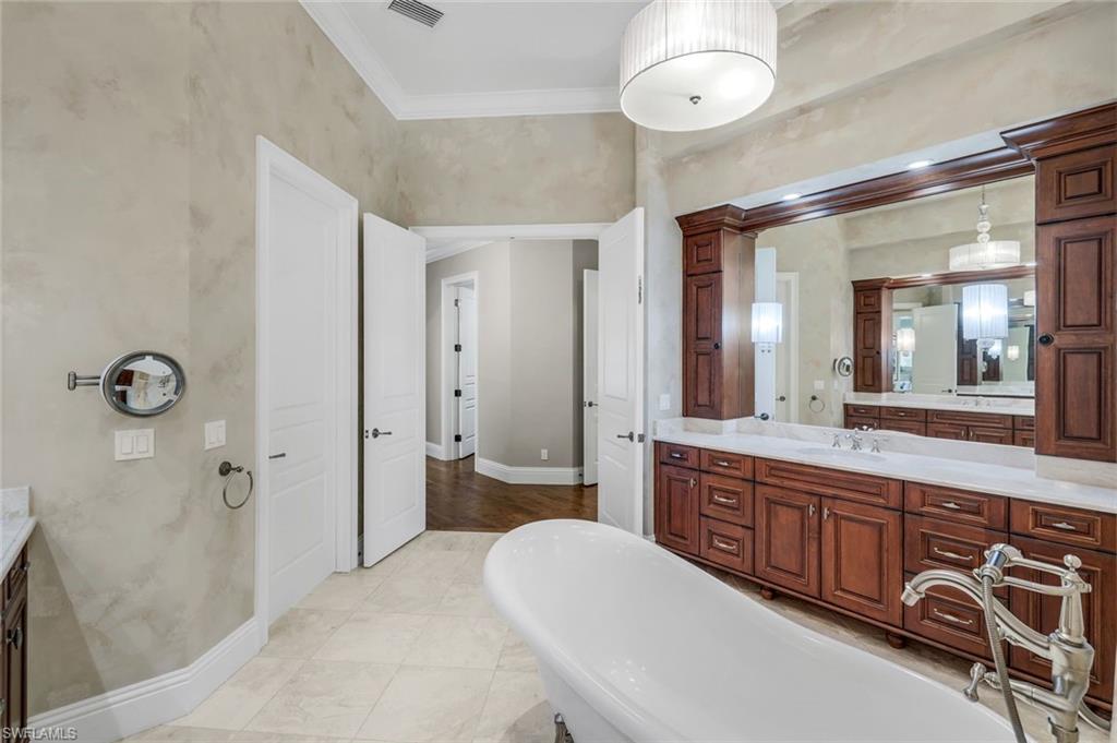 14459 Marsala Way Naples, FL 34109 - Photo 24 of 50 a spacious bathroom with a double vanity sink a mirror a bathtub and a shower