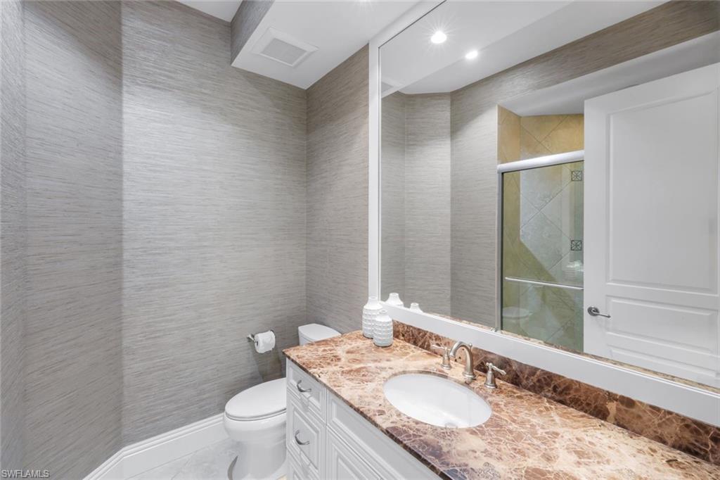 14459 Marsala Way Naples, FL 34109 - Photo 25 of 50 a bathroom with a granite countertop sink a toilet and a mirror