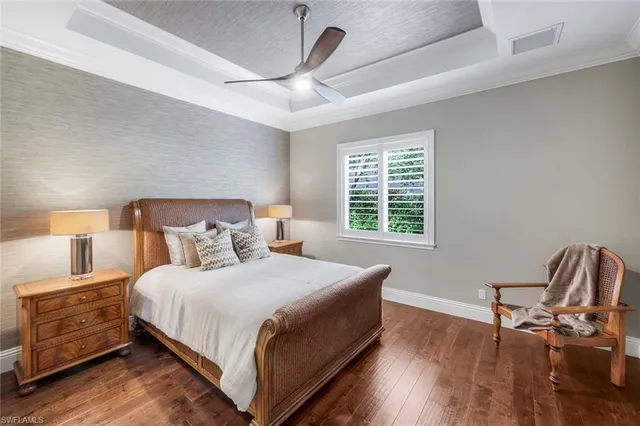 a bedroom with a bed a chair and a large window