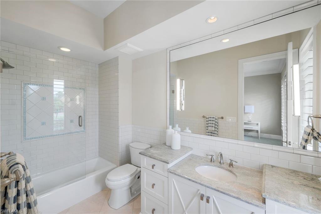 14459 Marsala Way Naples, FL 34109 - Photo 31 of 50 a bathroom with a granite countertop sink mirror vanity bathtub and a toilet