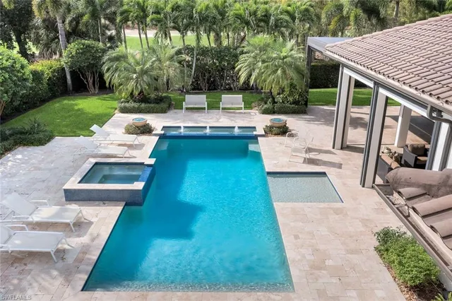 a view of a patio with couches table and chairs with plants and trees