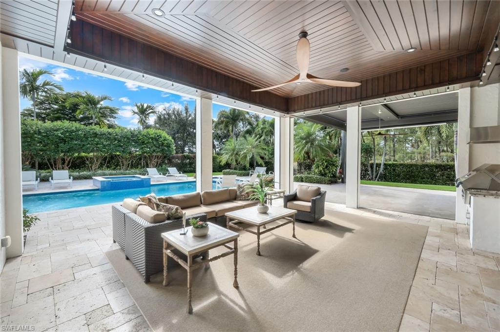 14459 Marsala Way Naples, FL 34109 - Photo 37 of 50 a living room with patio furniture and a floor to ceiling window
