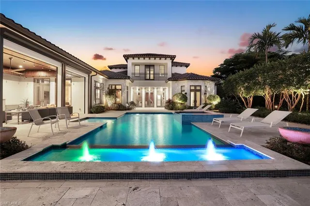 a view of a house with swimming pool and sitting area