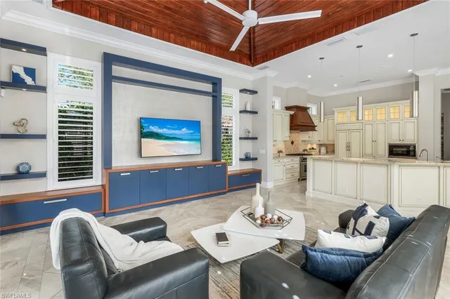 a living room with furniture kitchen view and a window