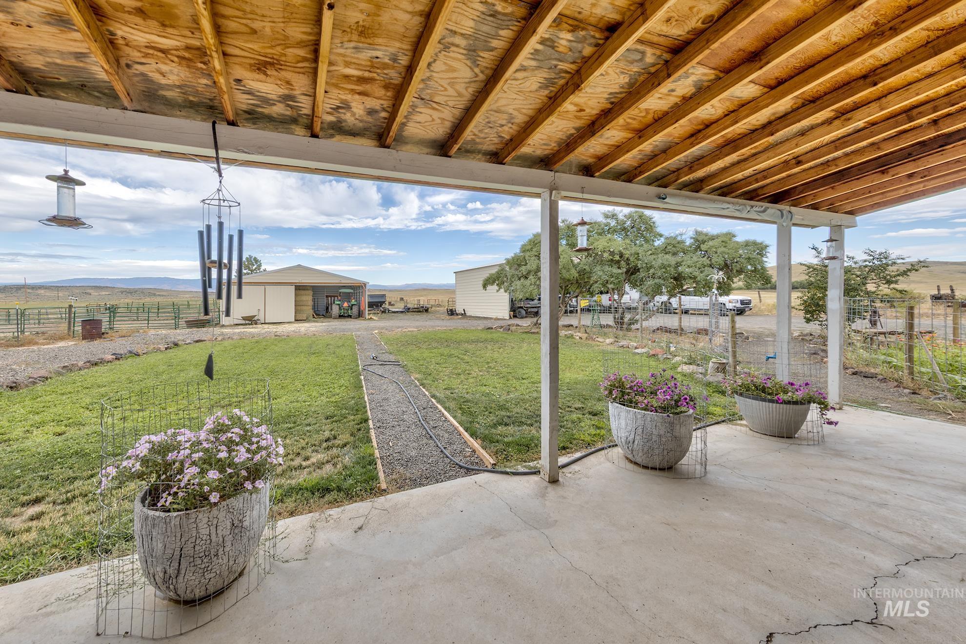 724 Mundy Gulch Road Indian Valley, ID 83632 - Photo 25 of 43 View of patio with a mountain view, an outdoor structure, and a view of rural / pastoral area