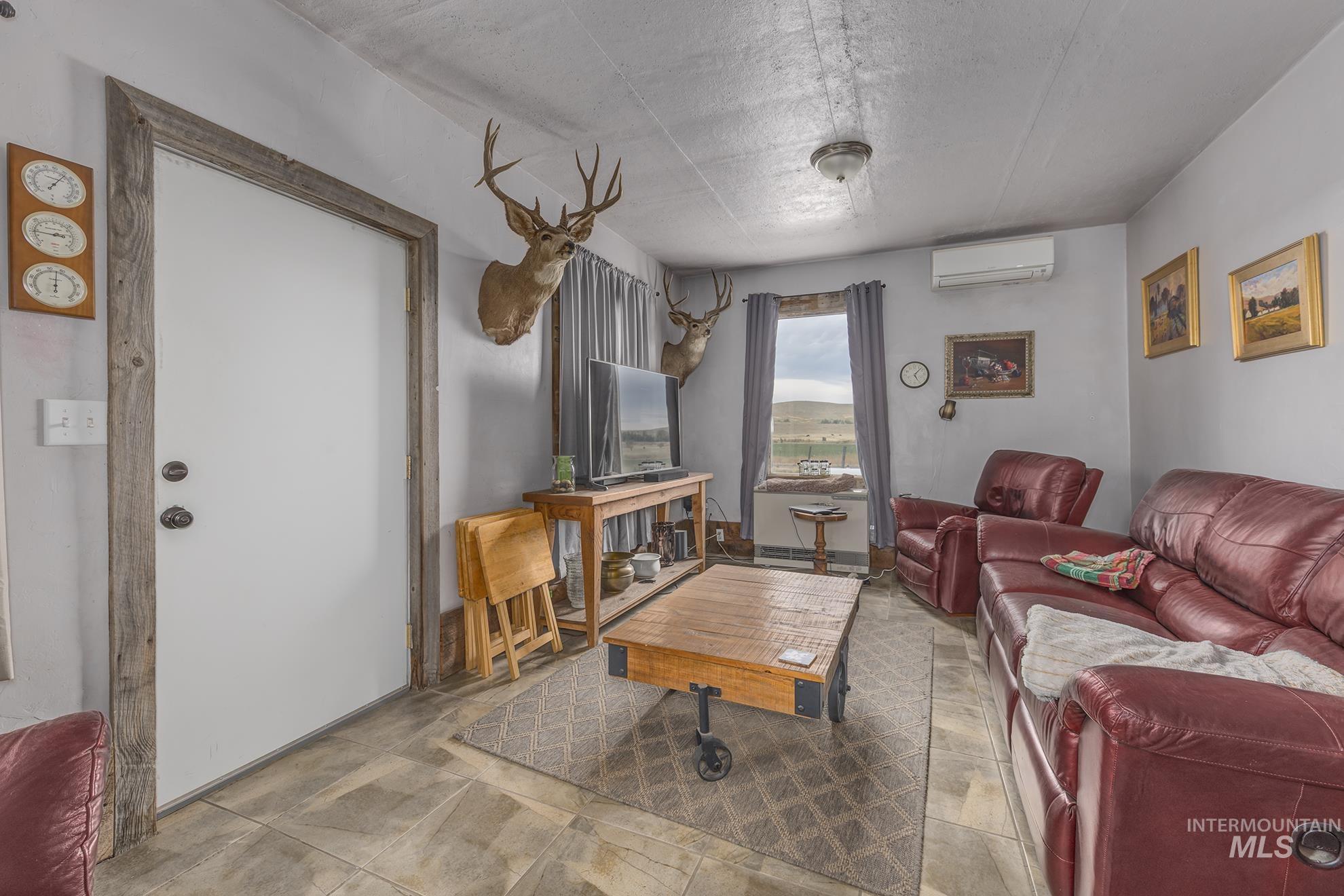 724 Mundy Gulch Road Indian Valley, ID 83632 - Photo 6 of 43 Living area with a textured ceiling and a wall unit AC