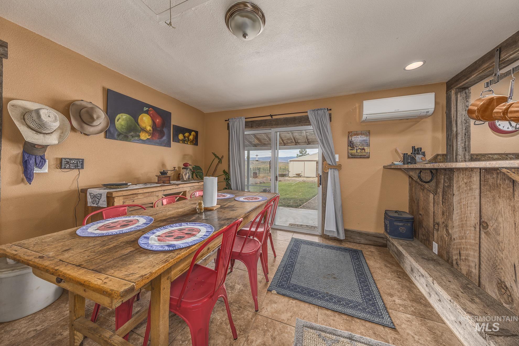 724 Mundy Gulch Road Indian Valley, ID 83632 - Photo 9 of 43 Dining room with an AC wall unit, tile patterned floors, and a textured ceiling