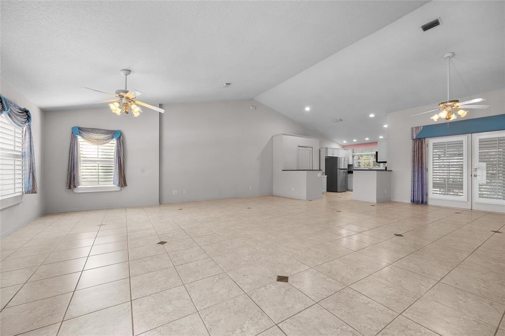 3951 Myrtle Street St. Augustine, FL 32084 - Photo 4 of 23 an empty room with a kitchen and chandelier fan
