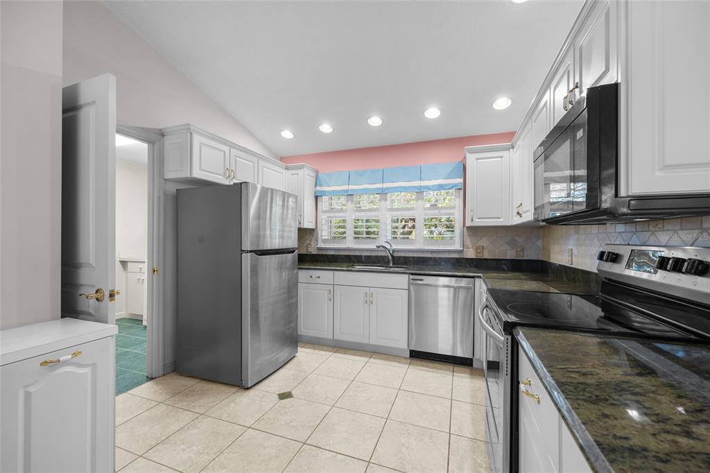 3951 Myrtle Street St. Augustine, FL 32084 - Photo 8 of 23 a kitchen with stainless steel appliances granite countertop a refrigerator sink and cabinets