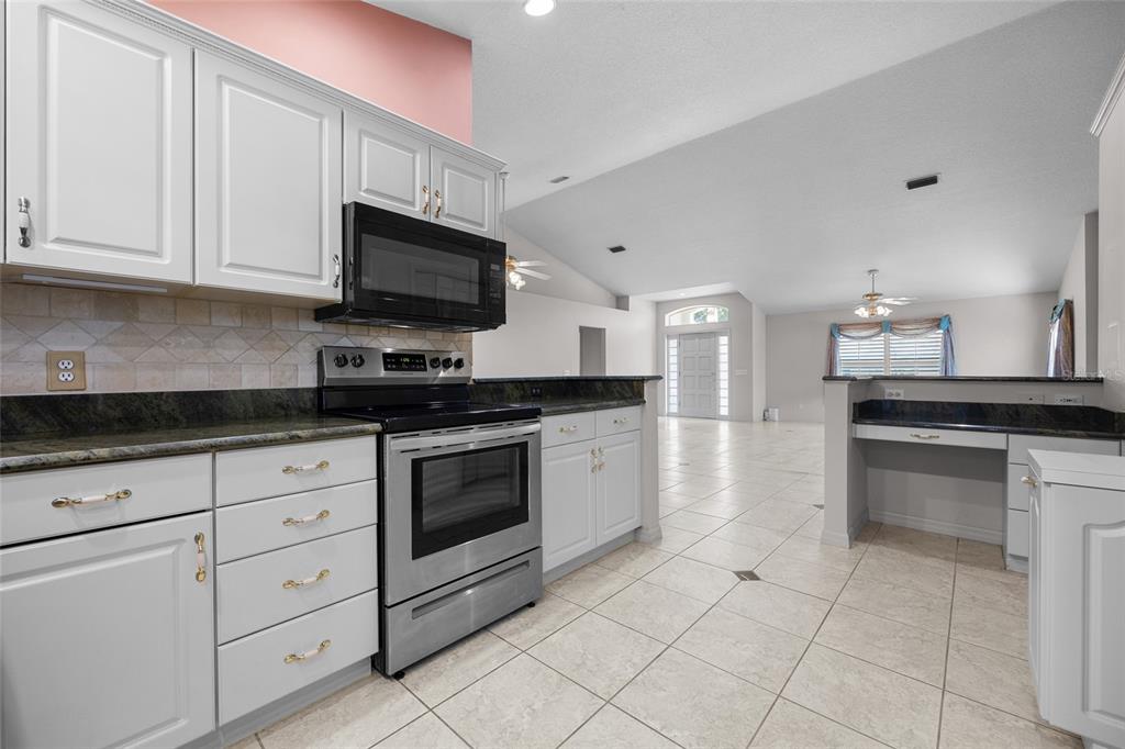 3951 Myrtle Street St. Augustine, FL 32084 - Photo 10 of 23 a kitchen with granite countertop white cabinets stainless steel appliances and sink
