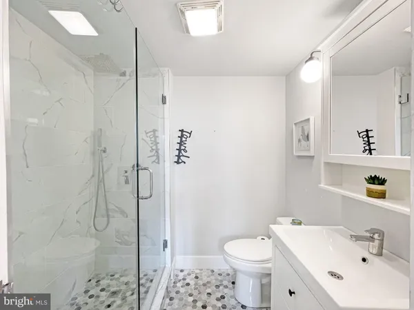 a bathroom with a sink a toilet and shower