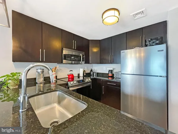 a kitchen with stainless steel appliances granite countertop a refrigerator sink and cabinets
