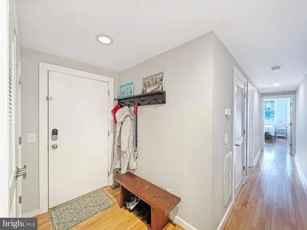 a view of a hallway with wooden floor and a livingroom