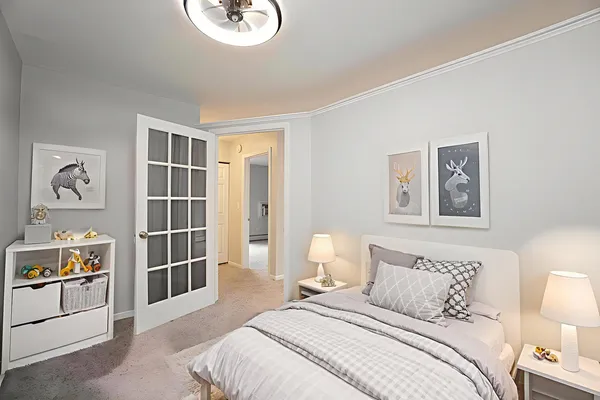 a bedroom with a bed and a lamp on dresser
