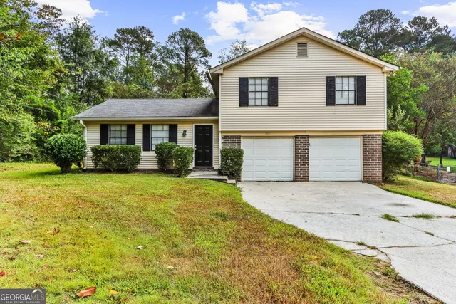 a front view of house with yard and trees around