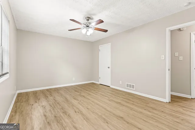 a view of an empty room with wooden floor