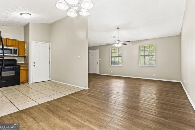 a view of an empty room with window and wooden floor