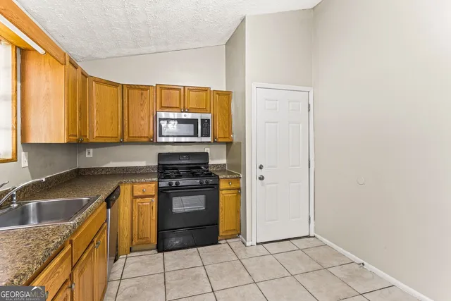 a kitchen with a sink a stove and cabinets