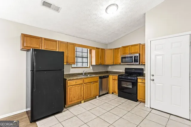 a kitchen with stainless steel appliances granite countertop a refrigerator and a sink