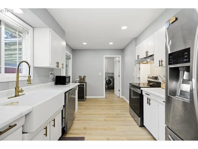 a kitchen with stainless steel appliances granite countertop a sink stove and refrigerator