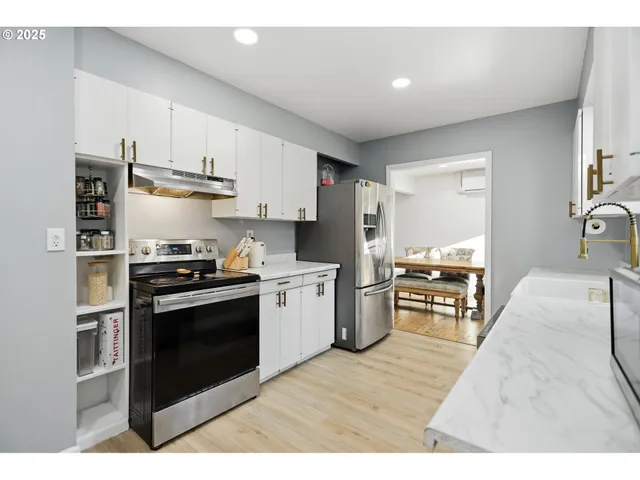 a kitchen with stainless steel appliances kitchen island granite countertop a refrigerator stove top oven and sink