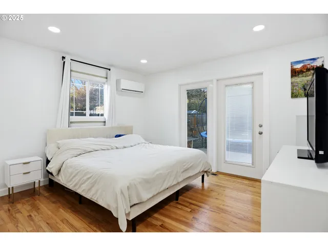 a bedroom with a bed window and a flat screen tv