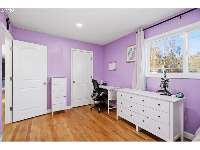 a bedroom with a dresser and a window