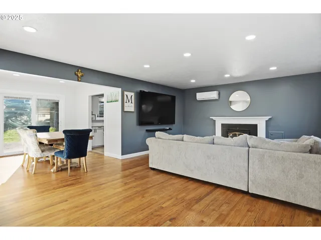 a living room with furniture flat screen tv and wooden floor