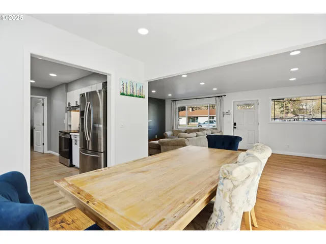 a living room with stainless steel appliances kitchen island granite countertop furniture and wooden floor