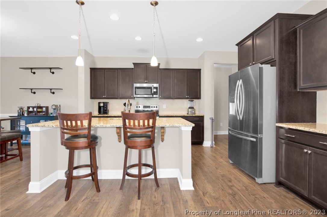 101 Carousel Street West End, NC 27376 - Photo 13 of 50 a kitchen with stainless steel appliances a refrigerator a stove a sink dishwasher and a refrigerator with wooden floor