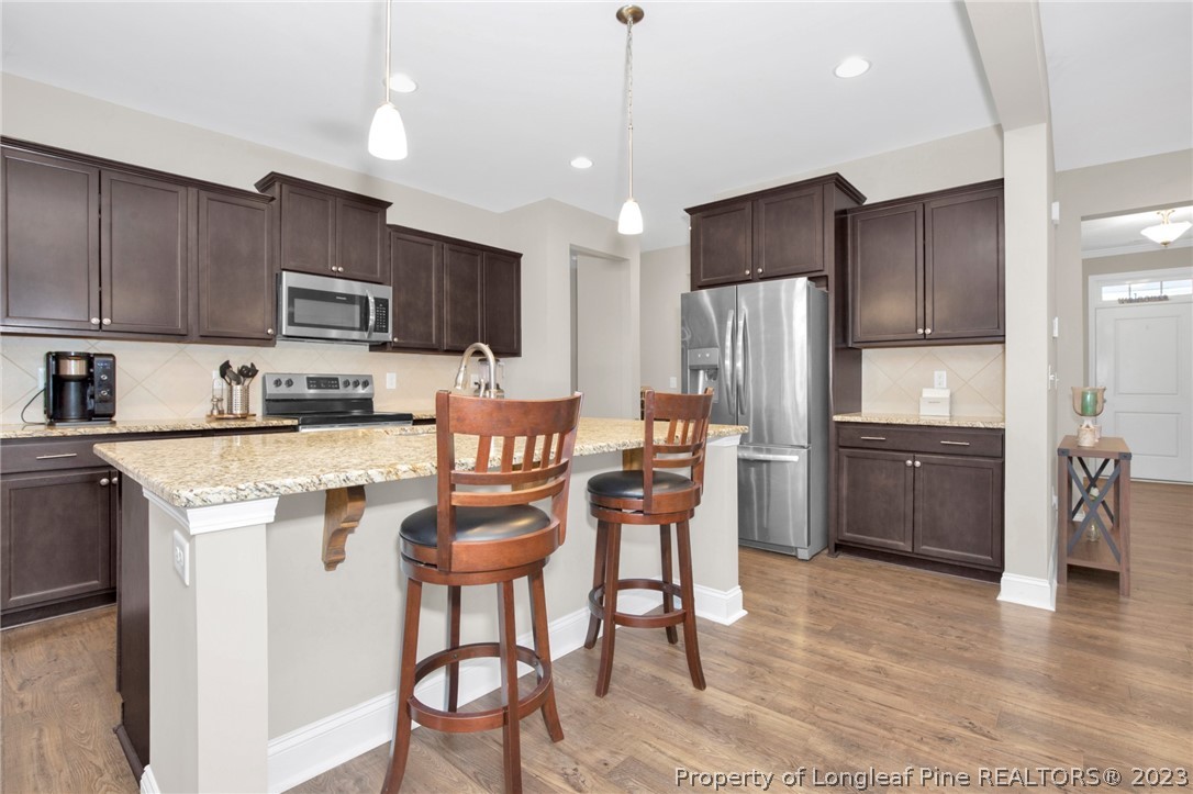 101 Carousel Street West End, NC 27376 - Photo 14 of 50 a kitchen with kitchen island a refrigerator stove and microwave