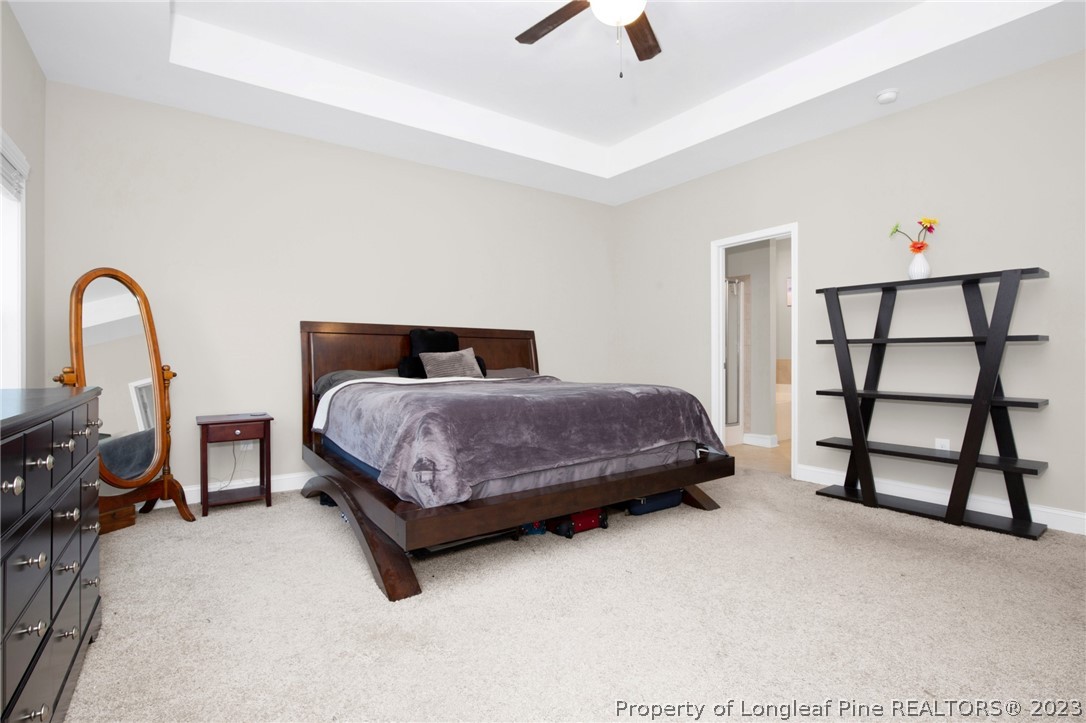 101 Carousel Street West End, NC 27376 - Photo 30 of 50 a bedroom with a bed a dresser and with potted plants