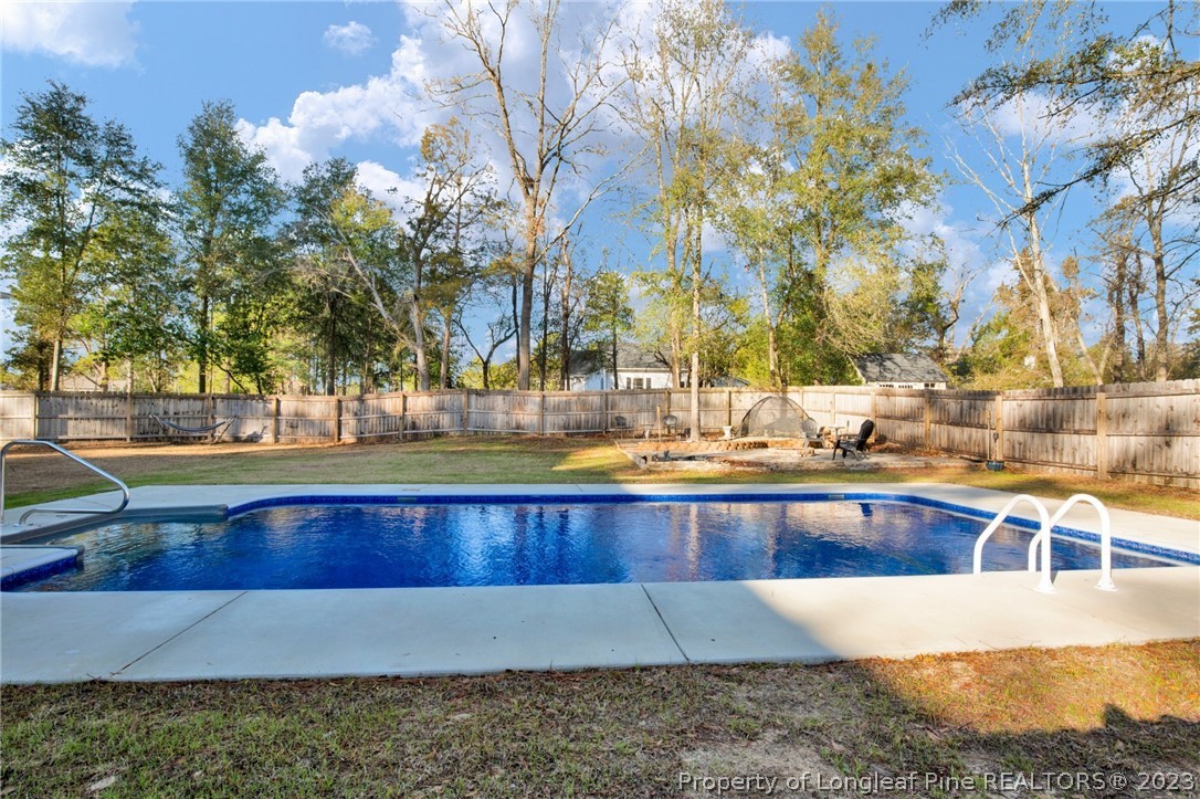 101 Carousel Street West End, NC 27376 - Photo 44 of 50 a view of swimming pool with outdoor seating and trees in the background