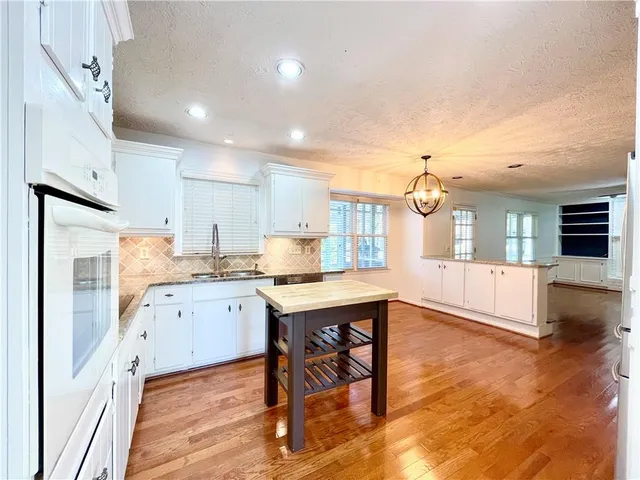 a kitchen with a table chairs refrigerator and cabinets