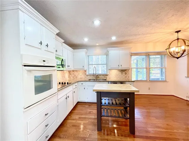 a kitchen with stainless steel appliances granite countertop a stove and cabinets