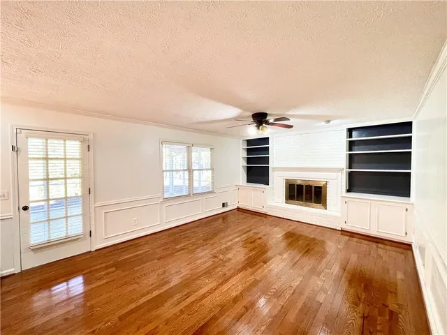 a view of a livingroom with wooden floor and a fireplace